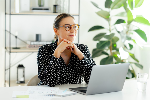 Woman at a clean desk with a laptop